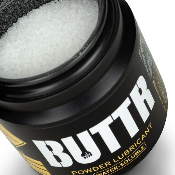 High-angle close-up looking into the open black jar filled with fine white lubricant powder.