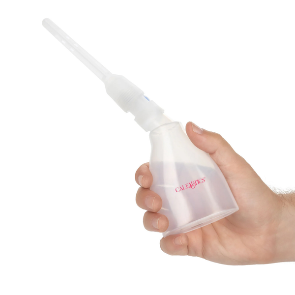 Scale perspective photo showing a hand squeezing the translucent bulb of the assembled douche device.