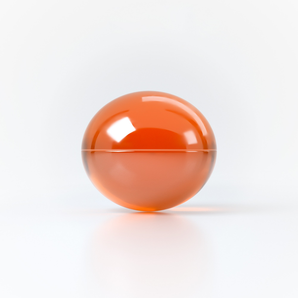 Studio product shot focusing on a single translucent orange oil sphere resting on a clean white reflective surface.