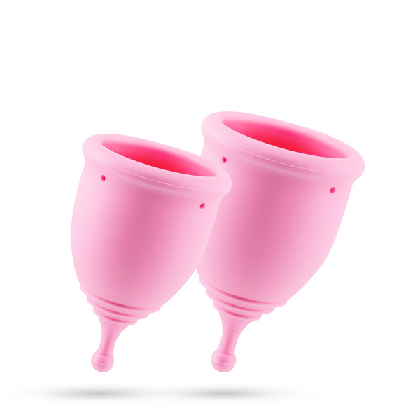 Two pink menstrual cups floating together on a white background.