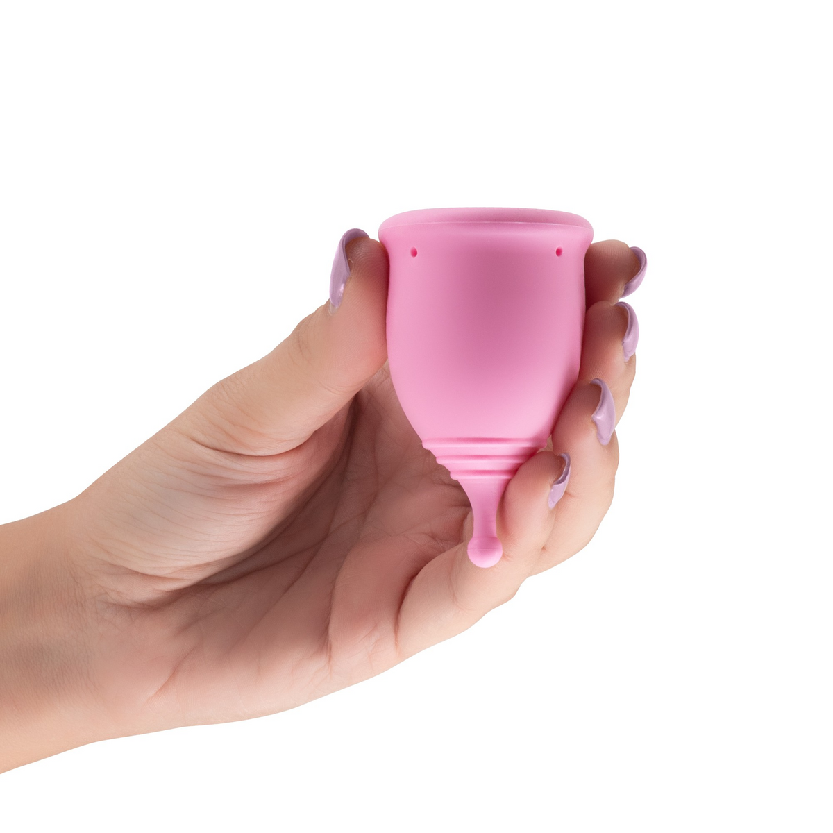 A hand with purple nail polish holding a pink menstrual cup.