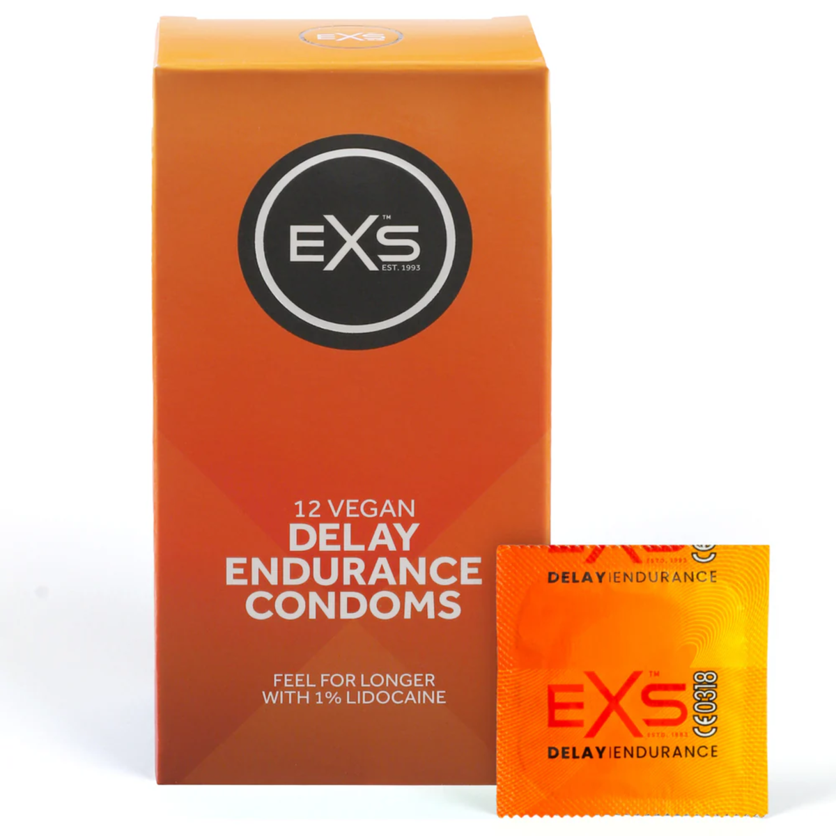 Studio product shot showing the orange box of EXS 12 Vegan Delay Endurance Condoms standing next to a single sealed orange foil wrapper against a white background. Imagen principal del producto