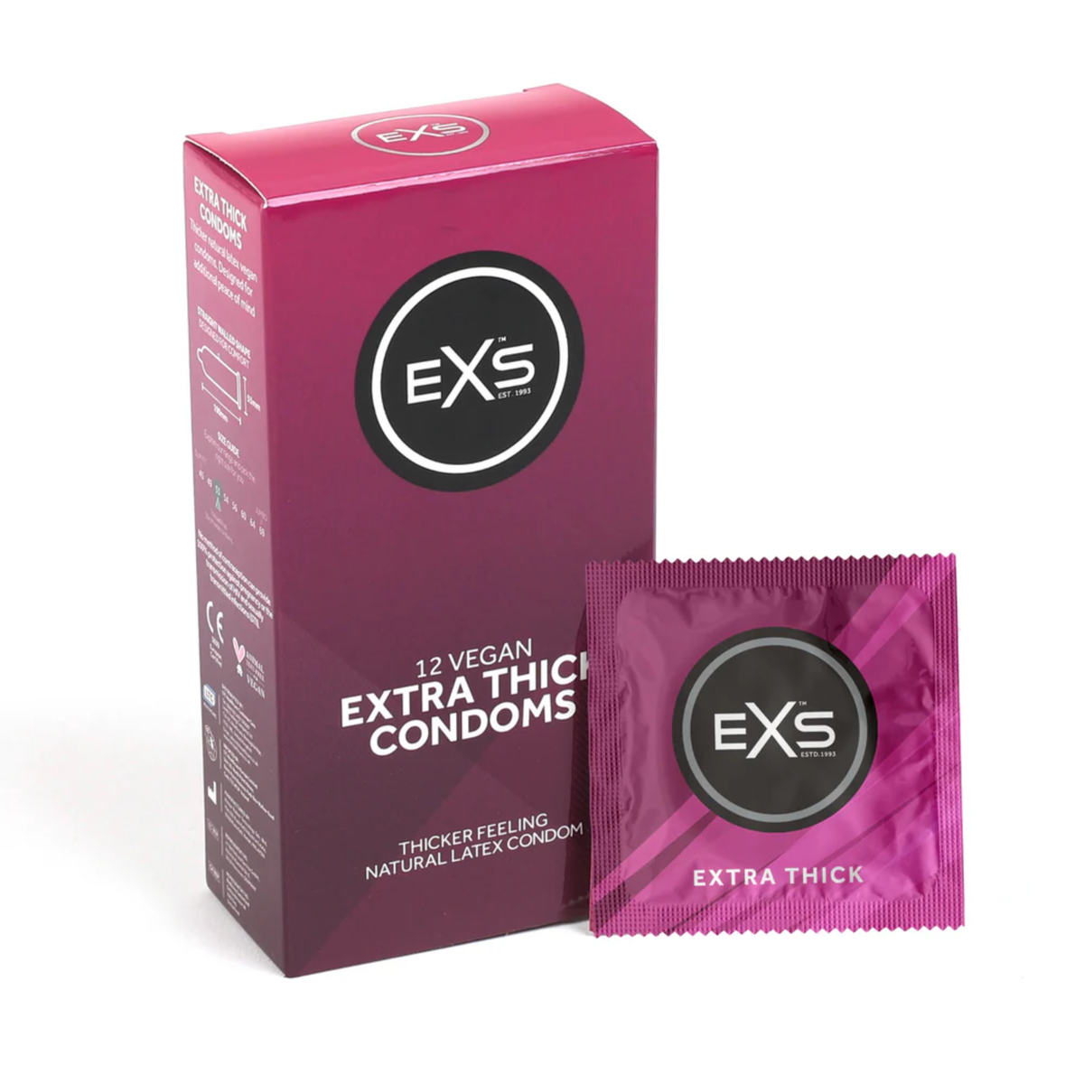 Studio product shot showing the magenta box of EXS 12 Vegan Extra Thick Condoms standing next to a single sealed magenta foil wrapper against a plain white background. Imagen principal del producto