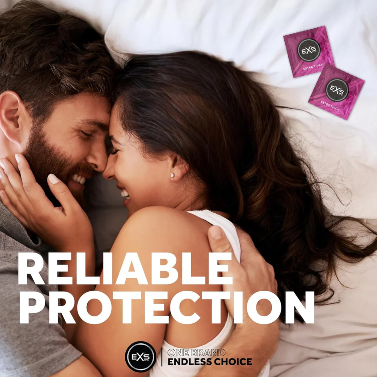 Lifestyle image of a smiling couple embracing closely in bed. Bold text overlay reads "RELIABLE PROTECTION," accompanied by two magenta EXS Extra Thick condom wrappers in the upper corner.