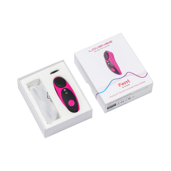 Unboxing photo showing the pink and black Lovense Ferri vibrator and USB charging cable resting inside the open white packaging box next to its lid.