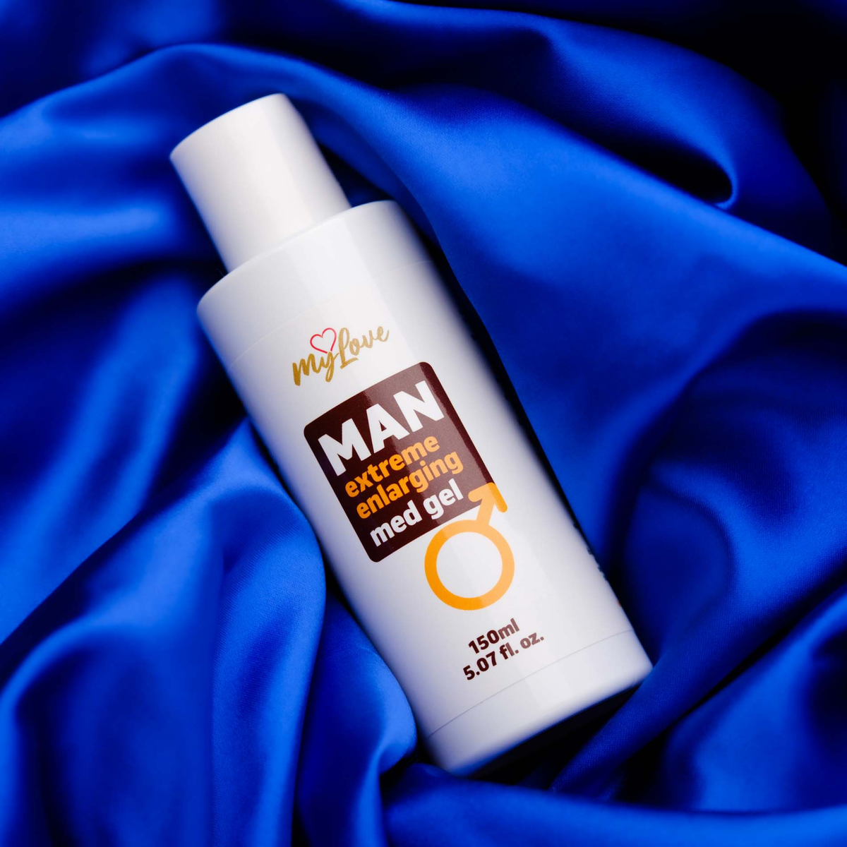 The 150 ml bottle of MyLove Man Extreme Enlarging Med Gel rests diagonally on draped, rich royal blue satin fabric.