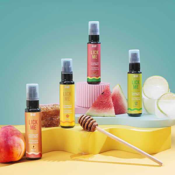 Five 'Lick Me' products on a colorful background with fruits and honeycomb.